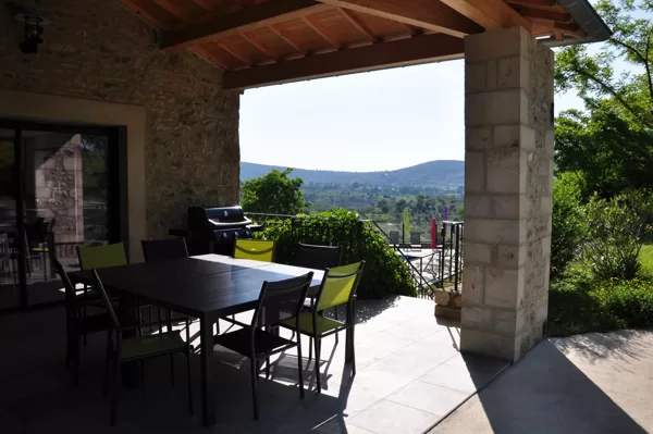 Terrase couverte : 2 tables et 12 chaises de jardin, barbecue à gaz WEBER